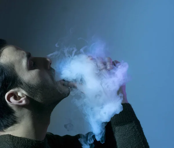 Hombre vapear un cigarrillo electrónico con mucho humo . — Foto de Stock