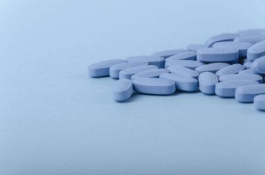 perspective view of blue medical tablets over a light blue backg clipart