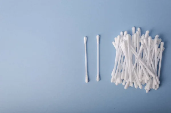 Heap of cotton swabs on light blue background, hygienic cosmetic