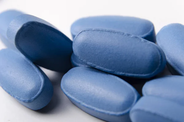 Zblízka modré pilulky nebo tablety na bílém pozadí. — Stock fotografie