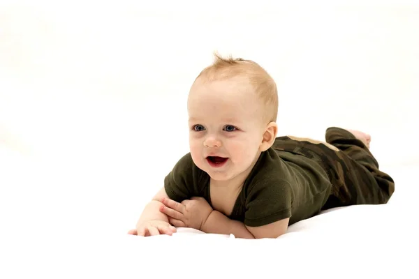 Leende spädbarn barn liggande på det vita täcket — Stockfoto