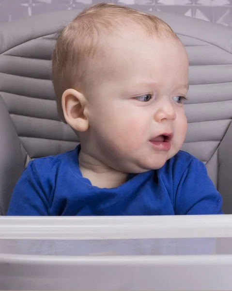 Расстроенный маленький ребенок в детском кресле смотрит в сторону — стоковое фото