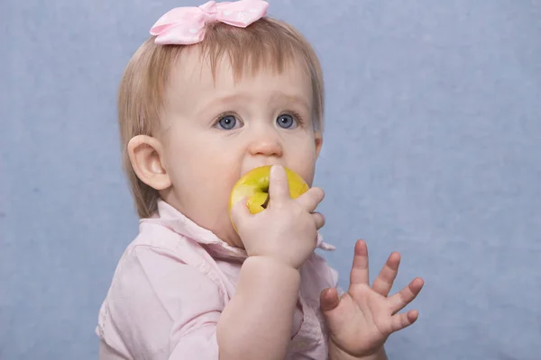 Милая маленькая девочка ест большое зеленое яблоко. Ретро-удар — стоковое фото