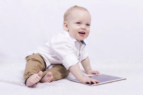 Linda sorrindo bebê bonito com um tablet — Fotografia de Stock