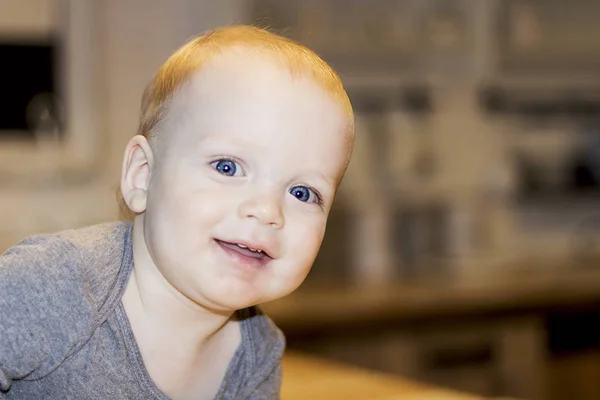 Smiling big-eyed toddler looking at camera on blurred background. Close-up — Stock Photo, Image