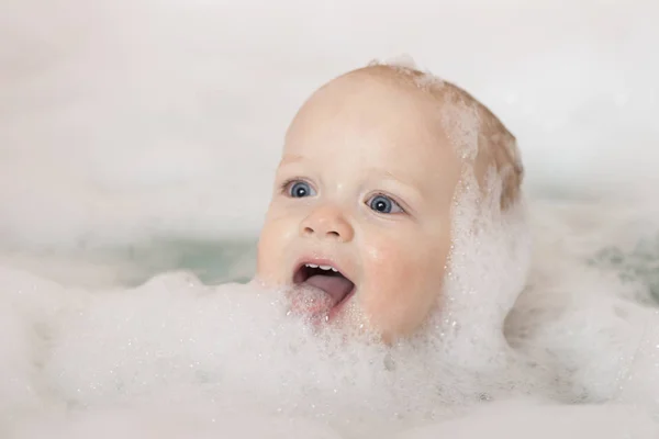 Счастливый мальчик в ванной. Забавный малыш Тоддлер с ягодицами на языке. Милый мальчик смеется, принимая ванну. — стоковое фото