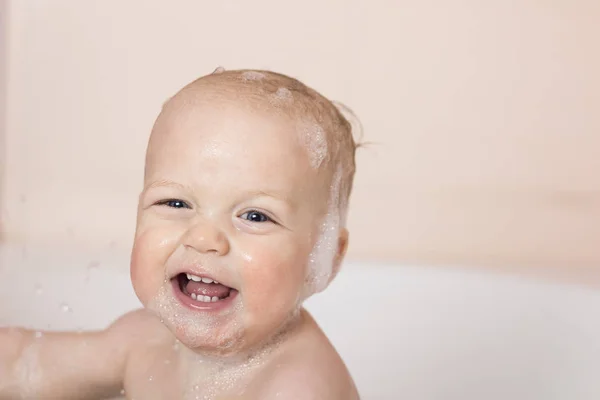 Ładny uśmiechnięty chłopiec dziecko w wannie. Laughes śmieszne niemowlę noworodek i patrząc na kamery — Zdjęcie stockowe