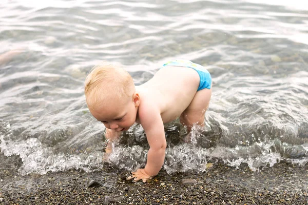 Bambino alle prese con un'onda sulla costa del mare — Foto Stock