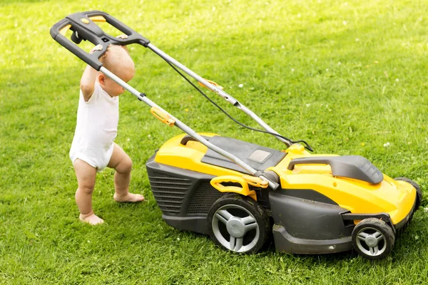 재미 있는 아기는 grassmower와 잔디 컷 — 스톡 사진