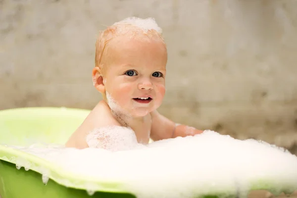 Милий малюк у мильній піні приймає ванну на відкритому повітрі — стокове фото