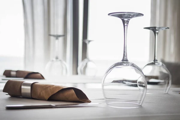 Catering table set service with silverware, napkin and glassware at restaurant. shot against window — Stock Photo, Image