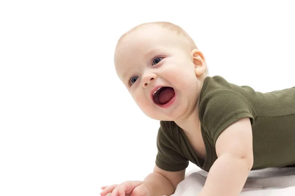 Söta leende spädbarn kid på vit bakgrund. Rolig skrattande pojke handpåläggning det vita täcket — Stockfoto