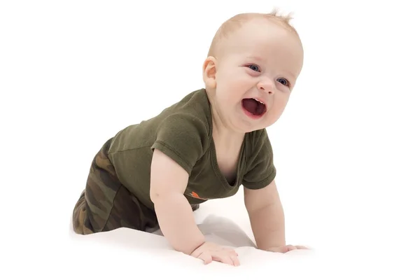 Rolig skrattande pojke kryper på det vita täcket mot isolerade vit bakgrund — Stockfoto