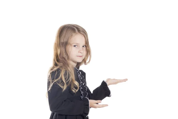 Portrait of cute little girl holding something on hand, looking at camera. White studio background. Isolated — Stock Photo, Image