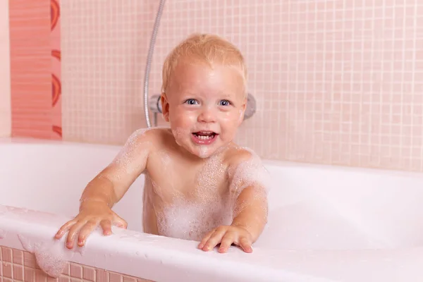 Ładny maluch uśmiechający się przy kąpieli. Zabawny malucha w piany mydlanej — Zdjęcie stockowe
