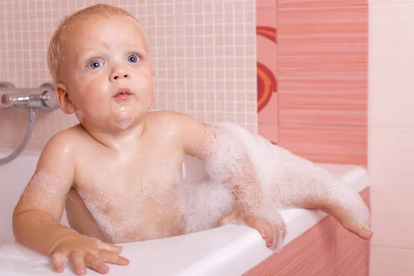 Смішний малюк намагається залишити ванну . — стокове фото