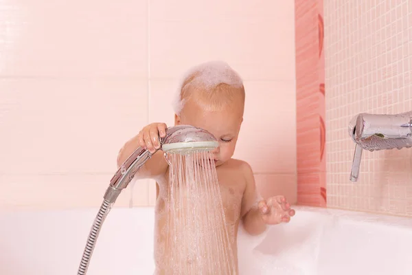 Adorable baby boy in a foam taking a douche, shower — Stock Photo, Image
