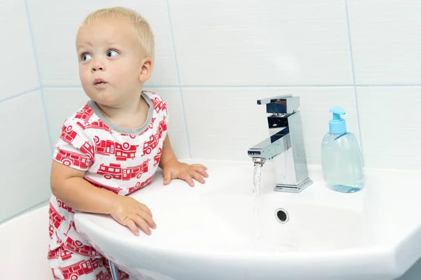 Макро портрет смішні білий кавказьких хлопчик малюка один рік старий миття рук у ванній кімнаті і дивлячись здивований схвильований, граючи з водою — стокове фото