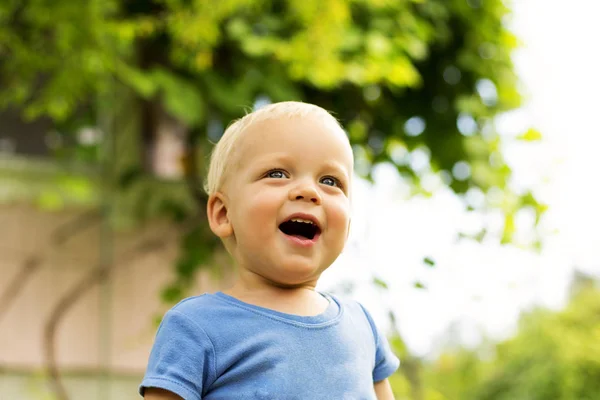 Close-up portret van schattige lachende babyjongen op de achtergrond wazig natuur. — Stockfoto