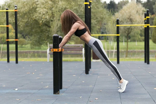 适合女孩在公园温暖的夏日里进行户外跳板锻炼。耐力和动机的概念 — 图库照片