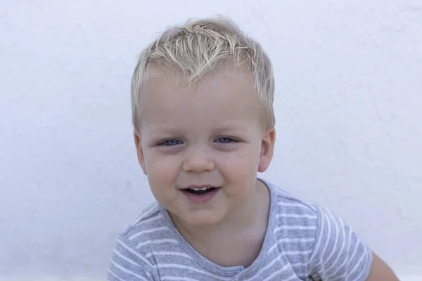 Emociones. Feliz niño contra la pared. Primer plano retrato de lindo niño sonriente —  Fotos de Stock