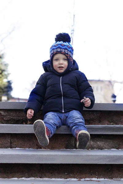 Забавный 2 года ребенок сидит на бетонной лестнице — стоковое фото