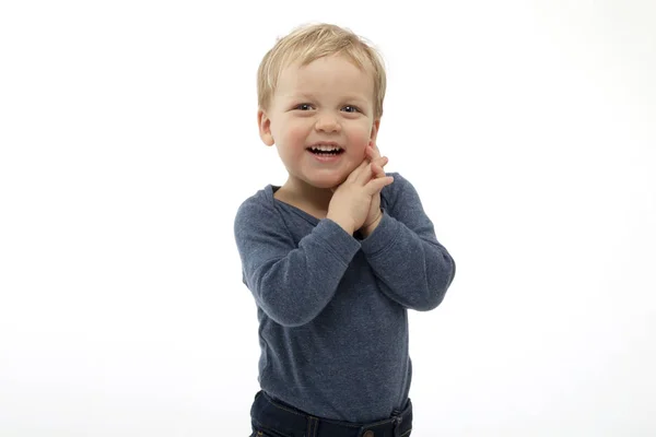 Upphetsad två-årig pojke tittar på något med förvåning och glädje. Studio skott på vit bakgrund — Stockfoto