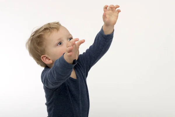Excited cute blond toddler holds up arms, isolated on white — Stock Photo, Image
