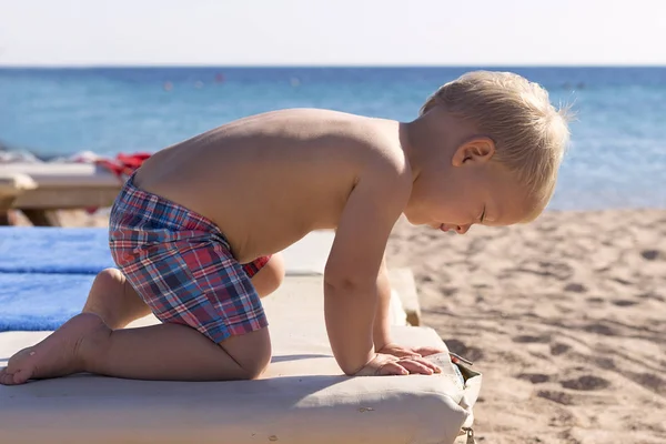 Schattig peuter rusten op het strand-zonnebank. Baby zomervakantie — Stockfoto