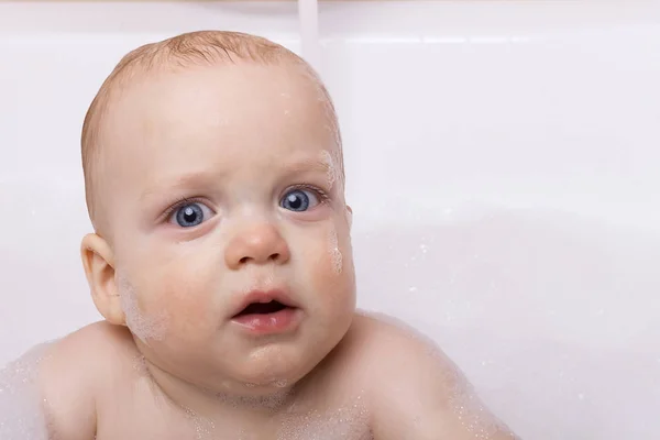 Słodkie małe dziecko dziecko z niebieskimi oczami. Zabawny malucha w piany mydlanej, patrząc na kamery. Miejsce — Zdjęcie stockowe