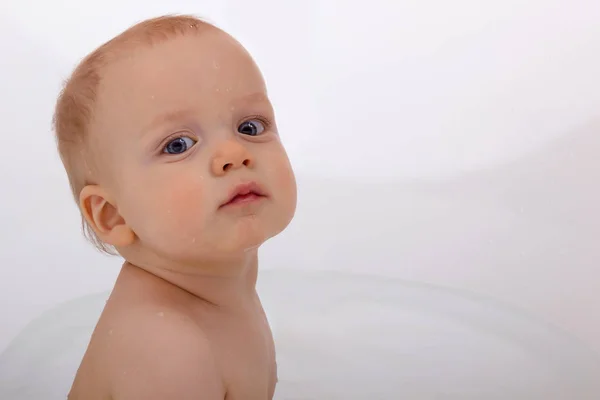 Χαριτωμένο μωρό αγόρι ενάντια σε λευκό φόντο. Αστεία βρέφος στην μπανιέρα και πρόσφατη φωτογραφική μηχανή τ. Χώρο αντίγραφο — Φωτογραφία Αρχείου