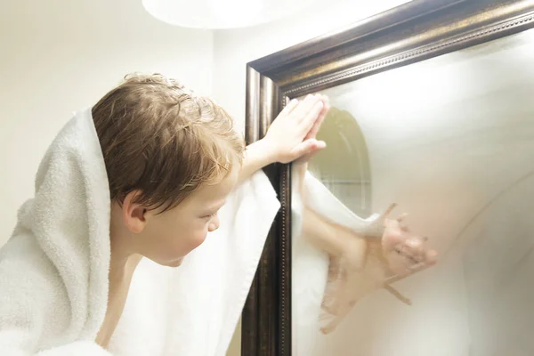 Милий маленький хлопчик, дивлячись у дзеркало після прийняття душу — стокове фото