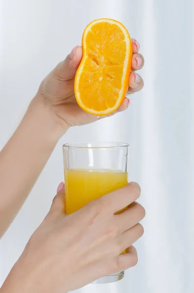 Girl's hand squeezing out juice — Stock Photo, Image