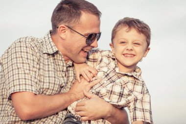 Baba ve oğul gün içinde plajda oynuyorlar. İnsanlar dışarıda eğleniyor. Arkadaş canlısı aile kavramı.