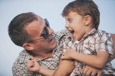Baba ve oğul gün içinde plajda oynuyorlar. İnsanlar dışarıda eğleniyor. Arkadaş canlısı aile kavramı.