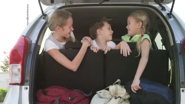 šťastné děti sedící ve dne v autě. Koncept šťastného mládí.