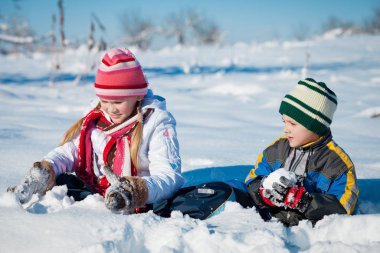 Kış günü karda oynayan sevimli küçük çocuklar. İnsanlar dışarıda eğleniyor. Mutlu yıllar kavramı.