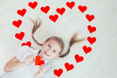 Yerde yatan küçük bir kız. Mutlu Sevgililer Günü kavramı.