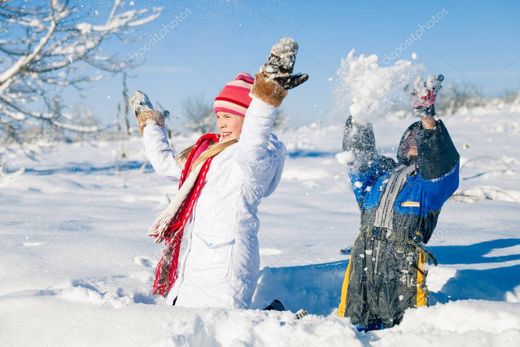 Cute little children playing  in snow at a winter day. People having fun outdoors. Concept of Happy new year.