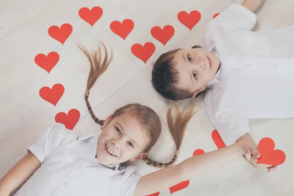 小男孩和小女孩躺在地板上 情人节快乐与兄妹永远在一起的理念 — 图库照片