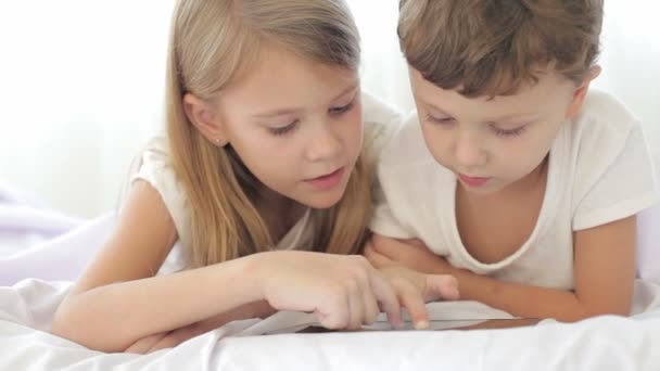可爱的男孩和他姐姐在家里看书 — 图库视频影像