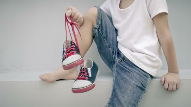 Little Boy Sitting House Keeping Youth Sneakers His Hands Day — Stock Video
