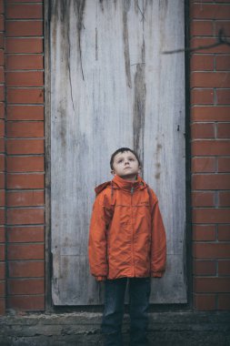 Gündüz vakti küçük üzgün bir çocuğun portresi. Kasvetli bahar kavramı.