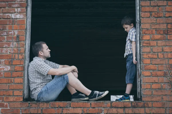年轻而悲伤的小男孩和父亲在白天坐在室外的画像 悲伤的概念 — 图库照片