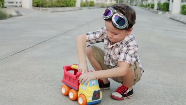 Szczęśliwy Mały Chłopiec Bawiący Się Drodze Zabawkowym Samochodem Ciągu Dnia — Wideo stockowe
