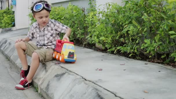 Fröhlicher Kleiner Junge Der Tagsüber Mit Spielzeugauto Auf Der Straße — Stockvideo