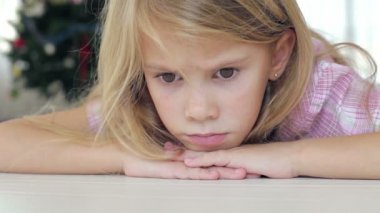 O gün evde yerde yatan üzgün küçük bir kızın portresi.