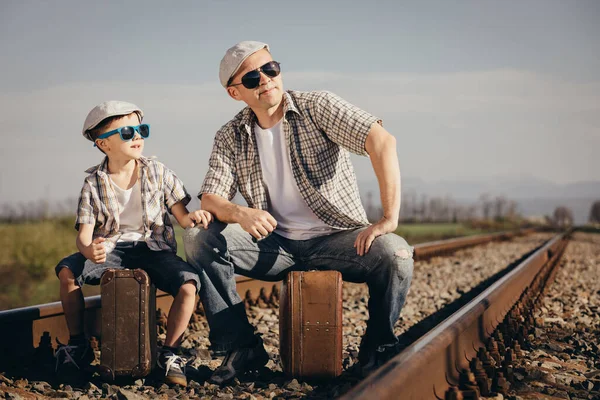 父と息子は 当時の鉄道のスーツケースを持って歩いています 屋外で楽しんでいる人 友好的な家族の概念 — ストック写真