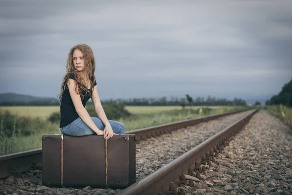 当時の電車の中で屋外のスーツケースに座っている若い悲しい10人の女の子の肖像画 悲しみの概念 — ストック写真