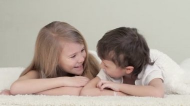 Evdeki yatakta yatan sevimli çocuklar. Kardeş kavramı. Sonsuza dek birlikte.